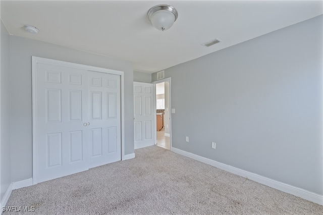 unfurnished bedroom featuring a closet and carpet flooring