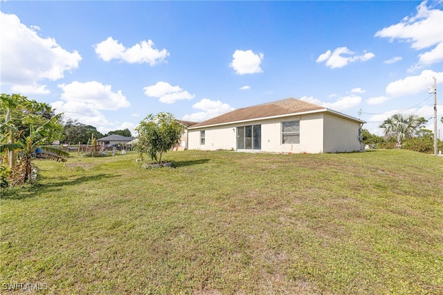 rear view of house featuring a lawn