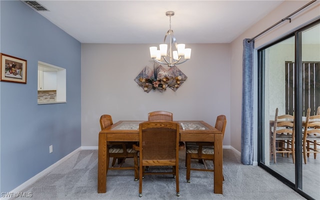 carpeted dining room featuring a chandelier