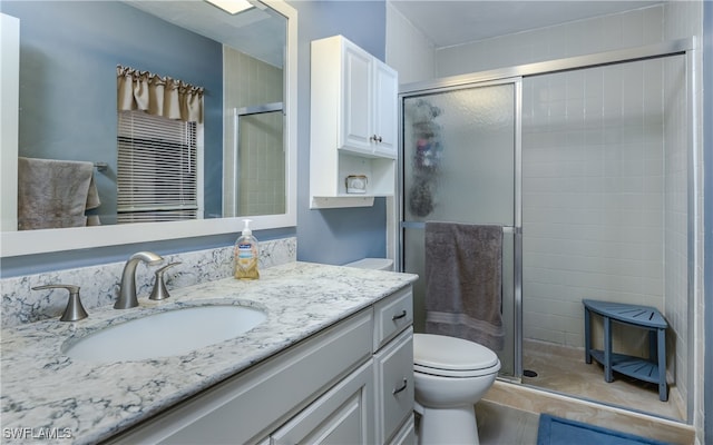 bathroom featuring vanity, toilet, and an enclosed shower