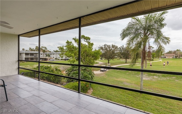 unfurnished sunroom featuring ceiling fan