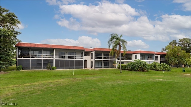 rear view of property with a lawn and a balcony