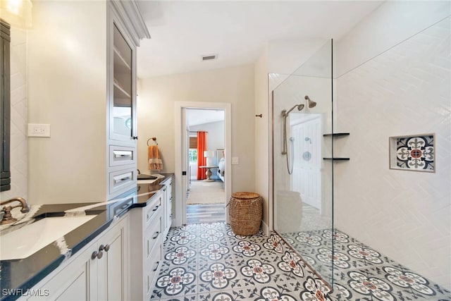 bathroom featuring vanity, vaulted ceiling, and walk in shower