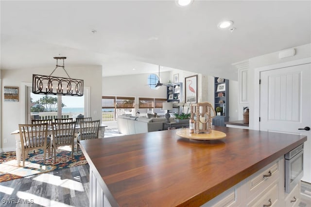 dining room with an inviting chandelier, vaulted ceiling, and light wood-type flooring