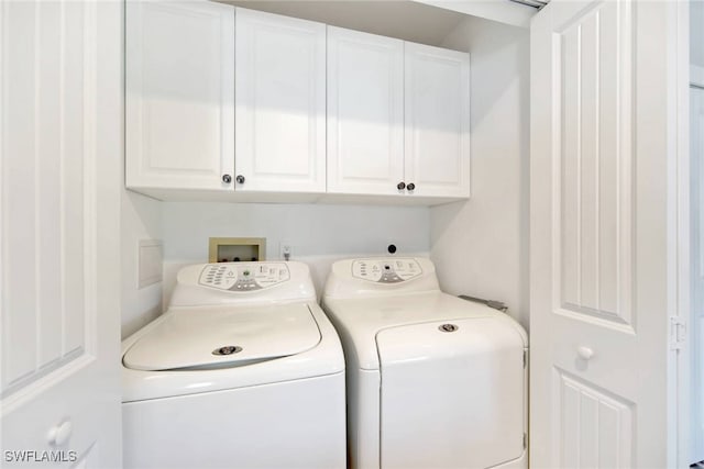 washroom with washing machine and dryer and cabinets