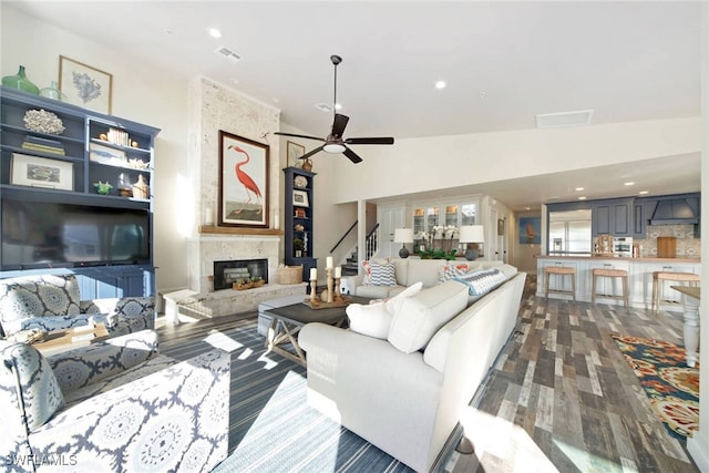 living room with dark hardwood / wood-style floors, ceiling fan, a fireplace, and vaulted ceiling