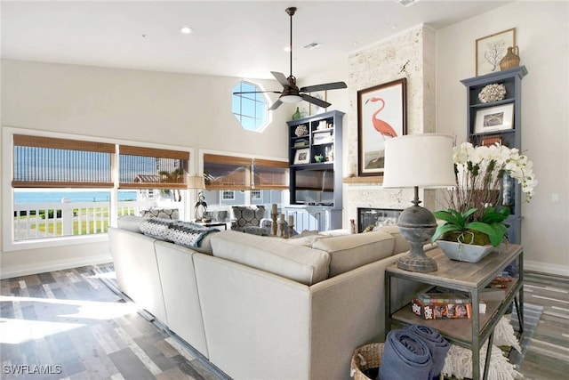 living room with hardwood / wood-style floors, plenty of natural light, ceiling fan, and high vaulted ceiling