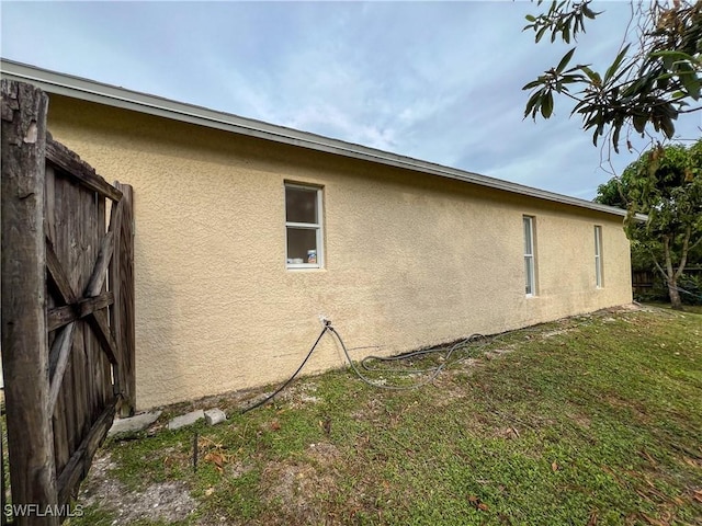 4895 Golfview Blvd, Lehigh Acres, FL 33973 - view of home's exterior with stucco siding and a lawn