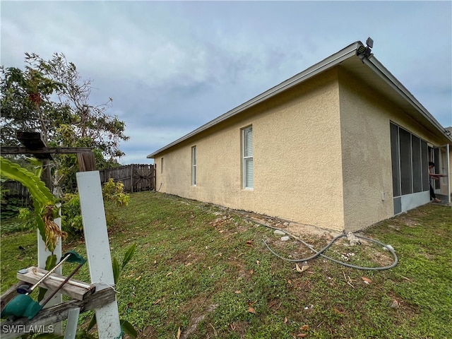 view of side of home with a yard and a sunroom