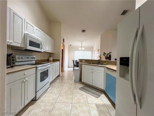 4895 Golfview Blvd, Lehigh Acres, FL 33973 - kitchen featuring white appliances, white cabinets, light tile patterned floors, and a peninsula