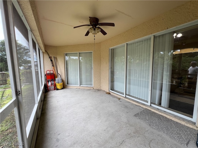 unfurnished sunroom with ceiling fan