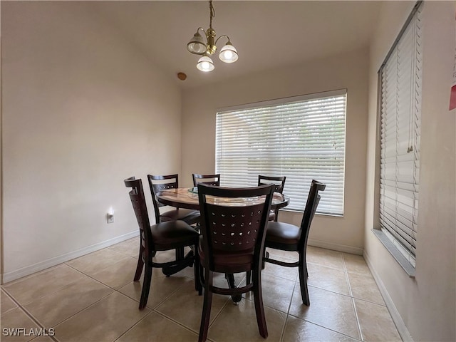 tiled dining space with an inviting chandelier and lofted ceiling