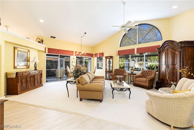 living room featuring hardwood / wood-style floors, ceiling fan with notable chandelier, and high vaulted ceiling