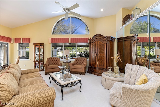 carpeted living room with high vaulted ceiling and ceiling fan