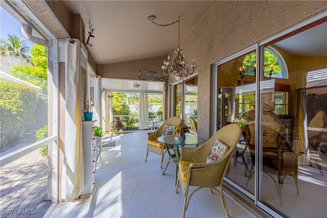 sunroom / solarium with an inviting chandelier and vaulted ceiling