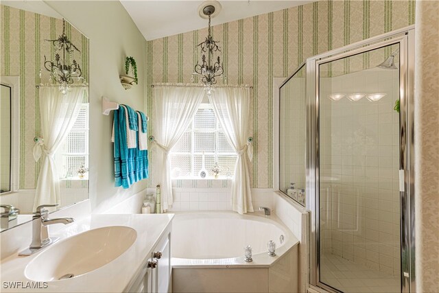 bathroom with shower with separate bathtub, vanity, a healthy amount of sunlight, and a notable chandelier