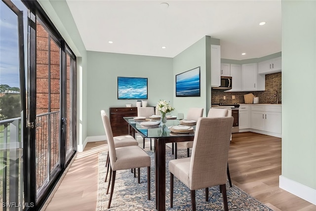 dining area with sink and light hardwood / wood-style flooring