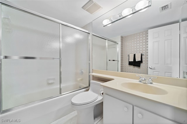 full bathroom with tile patterned floors, vanity, enclosed tub / shower combo, and toilet