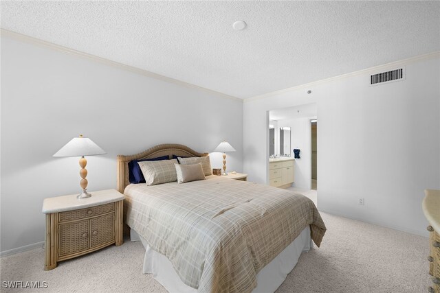 carpeted bedroom featuring a textured ceiling and ensuite bathroom