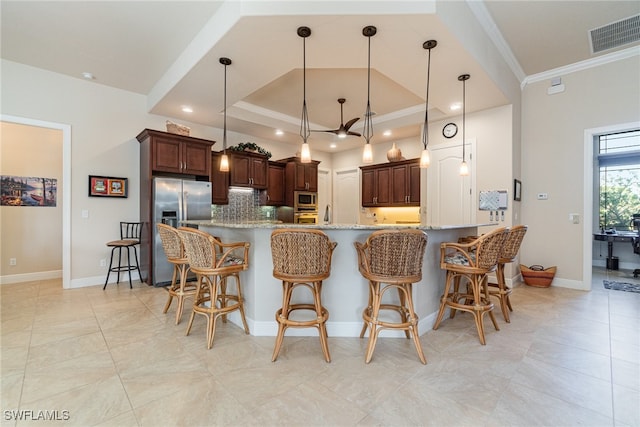 kitchen featuring a breakfast bar, crown molding, stainless steel appliances, visible vents, and backsplash