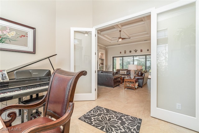 office space featuring baseboards, coffered ceiling, ceiling fan, ornamental molding, and beam ceiling