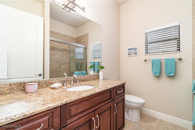 bathroom with toilet, a shower stall, vanity, tile patterned flooring, and baseboards