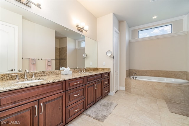 full bathroom with a bath, double vanity, and a sink