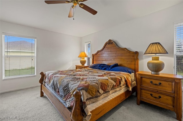 carpeted bedroom with ceiling fan and multiple windows