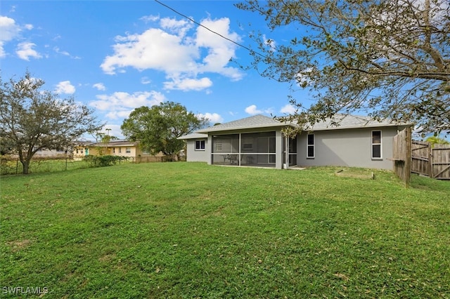 rear view of property with a lawn and a sunroom