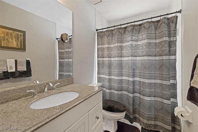 bathroom featuring vanity, toilet, and curtained shower