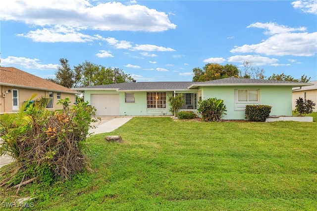 view of front of house featuring an attached garage, driveway, a front yard, and stucco siding