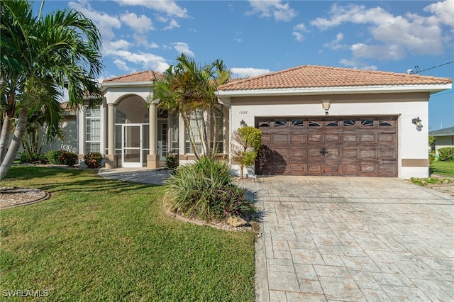 mediterranean / spanish house with a front lawn and a garage