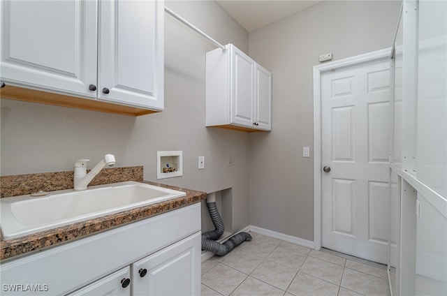 washroom featuring light tile patterned floors, washer hookup, sink, and cabinets