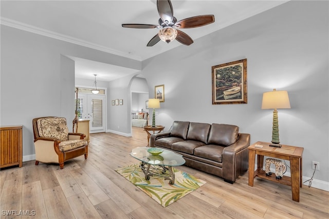 living room with ornamental molding, light wood-type flooring, and ceiling fan