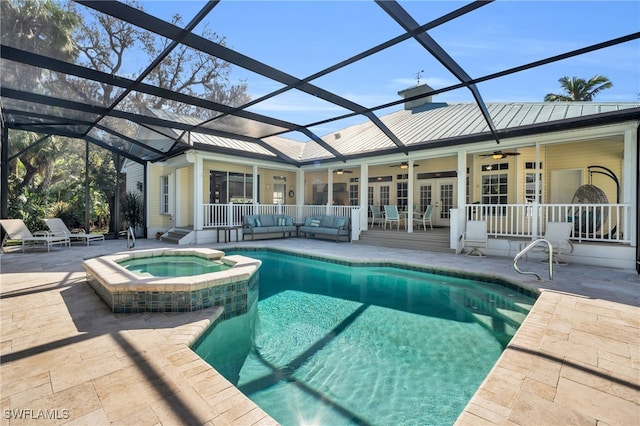 view of swimming pool with a patio, a lanai, an in ground hot tub, and ceiling fan