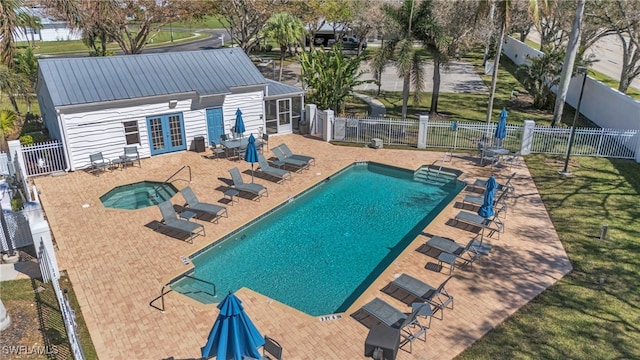 view of pool with a patio, french doors, a hot tub, and a lawn