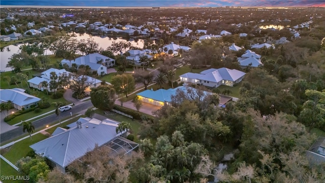 aerial view at dusk featuring a water view