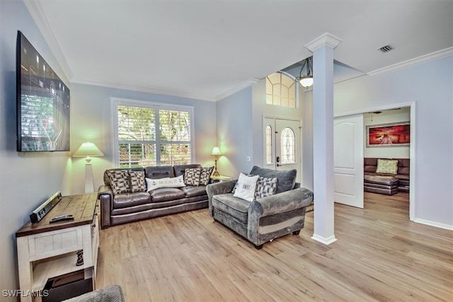 living room with ornate columns, light hardwood / wood-style floors, and crown molding