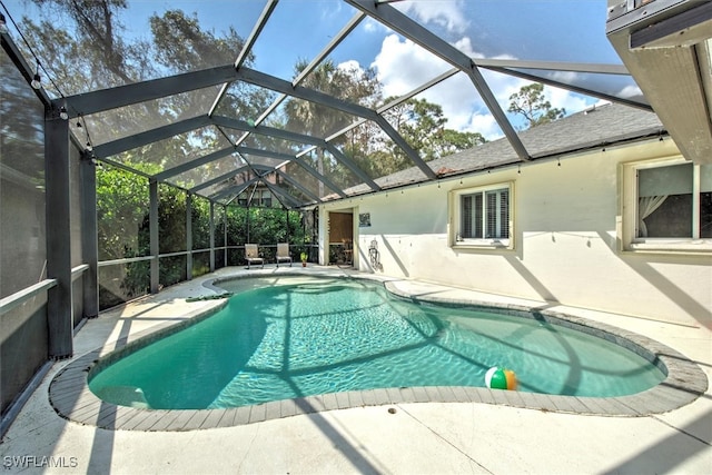 view of swimming pool with a patio area and a lanai