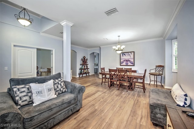 living room with ornamental molding, hardwood / wood-style floors, a notable chandelier, and ornate columns