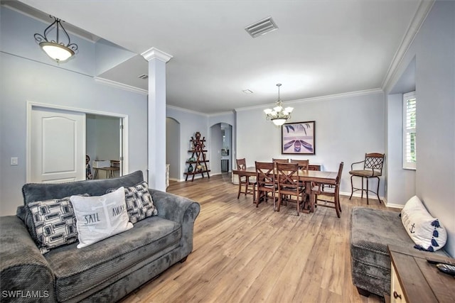 15600 Willow Oak Ct, Fort Myers, FL 33912 - living area featuring arched walkways, light wood-type flooring, a chandelier, decorative columns, and ornamental molding