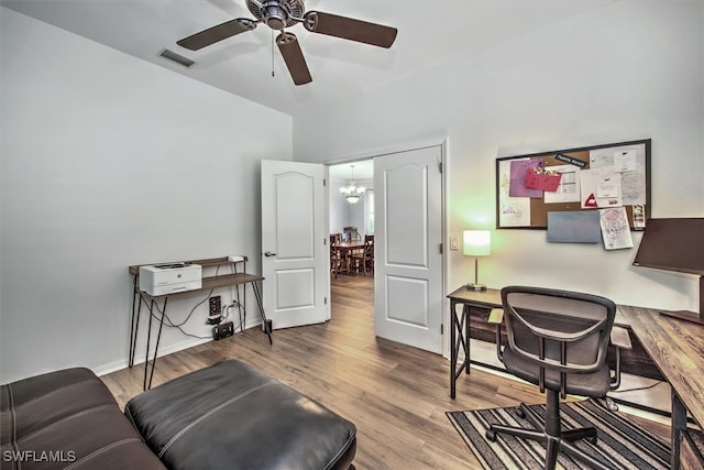 office space with light hardwood / wood-style floors and ceiling fan with notable chandelier