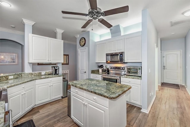 15600 Willow Oak Ct, Fort Myers, FL 33912 - kitchen featuring stainless steel appliances, a ceiling fan, white cabinetry, light wood-style flooring, and ornamental molding