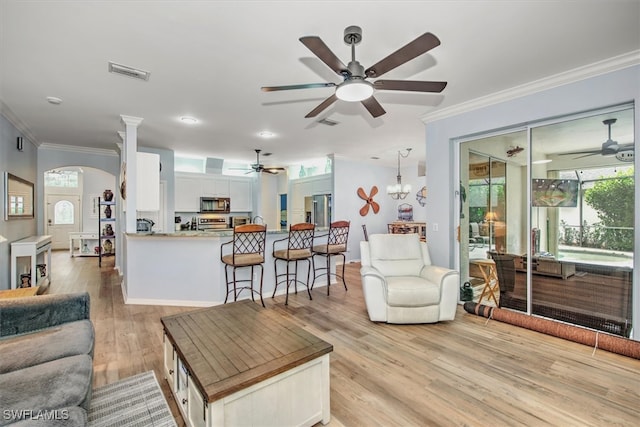 living room with crown molding and light hardwood / wood-style floors