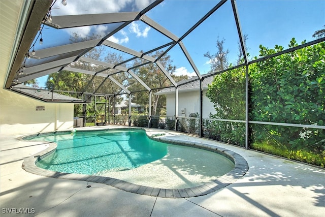 view of swimming pool with a patio area and a lanai