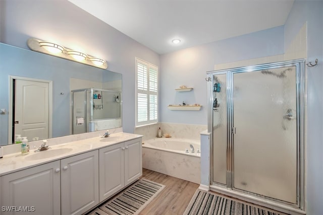 bathroom featuring vanity, hardwood / wood-style flooring, and plus walk in shower