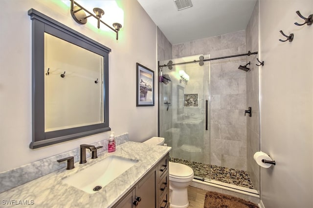 bathroom with vanity, toilet, walk in shower, and hardwood / wood-style floors