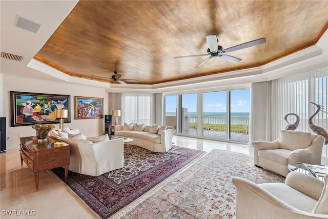 living room with a raised ceiling, a water view, crown molding, ceiling fan, and wood ceiling