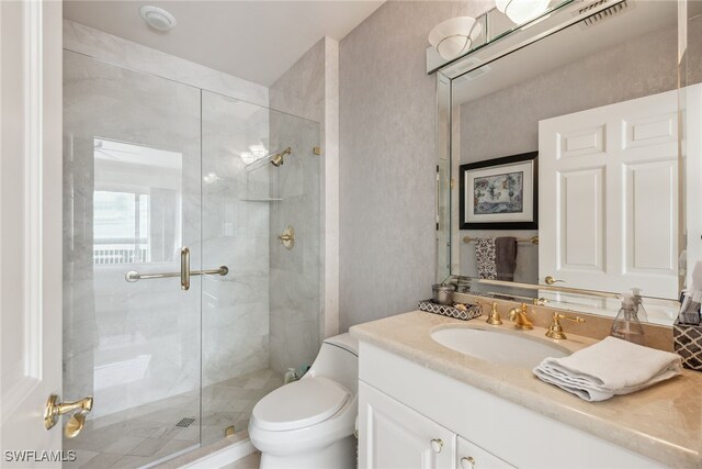 bathroom featuring vanity, an enclosed shower, and toilet