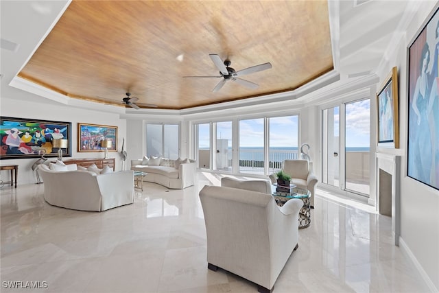 living room featuring a raised ceiling, ceiling fan, a water view, and wood ceiling